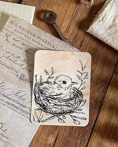 a rubber stamp with a bird's nest on it sitting next to some papers