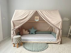 a child's bed with a canopy over it in the middle of a room