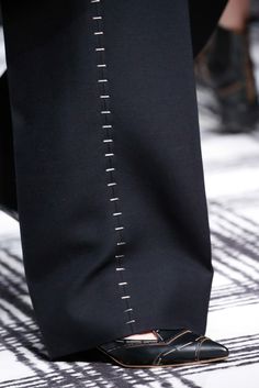 a person's feet with black shoes on the runway