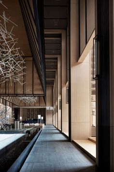 an empty hallway with lots of lights hanging from it's ceiling and wooden paneling