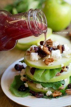 a plate topped with apples and cheese covered in nuts