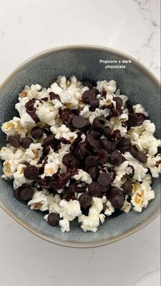 a bowl filled with popcorn and chocolate chips