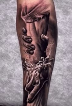 a man's leg with tattoos on it and his hands holding something in the air