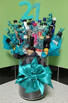 a bucket filled with lots of different types of alcohol and condiments in front of a green wall