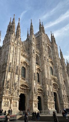 people are walking around in front of an ornate building