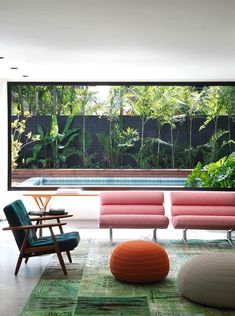 a living room filled with furniture next to a swimming pool