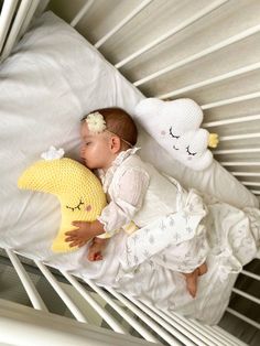 a baby sleeping in a crib with stuffed animals