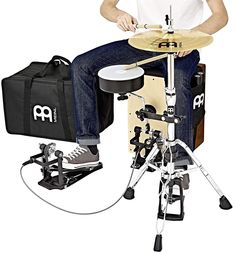 a man sitting on top of a drum set next to a bag and drumstick