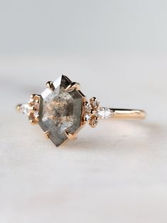 a close up of a ring with a stone and two diamonds on the front side