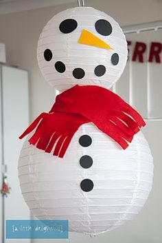 a paper snowman ornament hanging from the ceiling