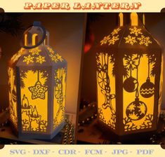 two decorative lanterns lit up in the night with christmas decorations on them, one is yellow and the other is blue