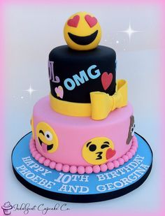 a pink and black cake with emoticions on it