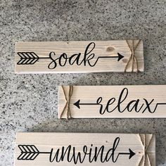 three wooden signs that say relax, unwind and soak with arrows on them