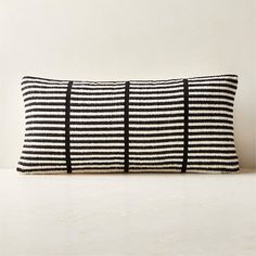 a black and white striped pillow sitting on top of a table