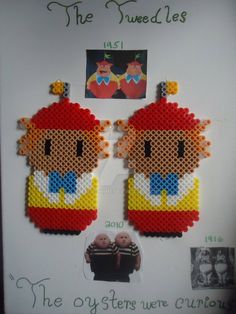 two cross stitch earrings with pictures of the same character on them, hanging from a white frame