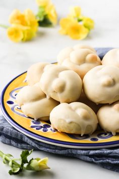 a plate filled with dumplings on top of a blue and yellow plate next to flowers