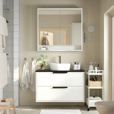 a bathroom with a sink, mirror and towel rack in it's center area