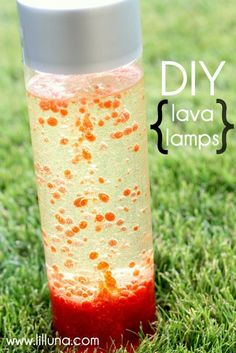 a red and yellow liquid bottle sitting on top of a green grass covered field with the words diy lava lamps