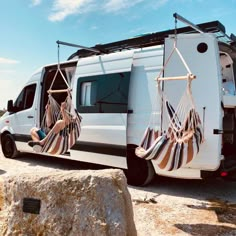 a white van with two hammocks hanging from it's roof and windows