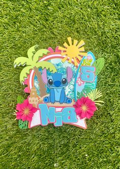 a paper cut out of an animal with flowers and palm trees in the background, on grass