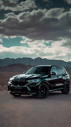 a black bmw suv parked in the desert