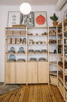 a room filled with lots of shelves and pictures on top of wooden flooring next to a white wall