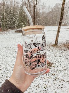 a person holding up a glass jar with butterflies on it and the words, antisocial butter