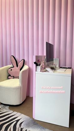 a chair and desk in front of a pink wall with vertical blinds on the walls