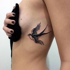 a woman's breast with a bird tattoo on it