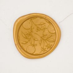 a gold plate with fruit and leaves on it