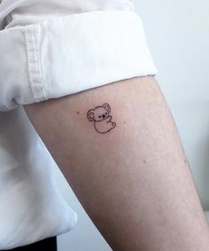 a small koala bear tattoo on the arm