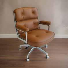 a brown office chair sitting on top of a hard wood floor next to a wall