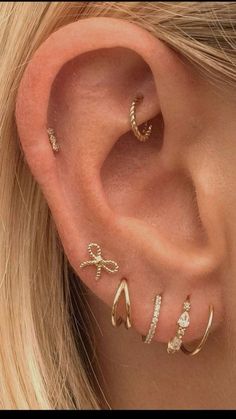 a woman wearing three different ear piercings