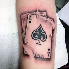 a black and white photo of a playing card tattoo on the arm