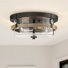 a light fixture in a living room with white walls and wood trim around the ceiling