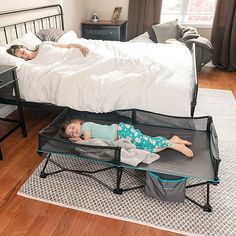 two children are laying on their beds in the middle of a room with hardwood floors