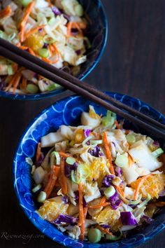 two blue bowls filled with food and chopsticks