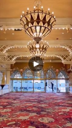 the inside of a large ballroom with chandelier and red carpeting on the floor