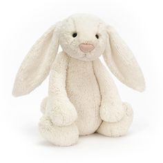 a white stuffed rabbit sitting up against a white background