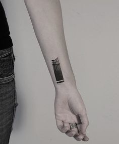 a person with a black and white tattoo on their arm holding the hand of another person