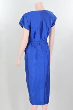 "This gorgeous dress is in excellent vintage condition: I can find no flaws. Please be sure to note the floral details with their midnight blue velvet inserts on the fitted bodice of the dress and the short capped sleeves that give extra room in the bust and the soft shoulder pad on either side; note, too, the sassy bow at the hip and the attached, asymmetrical peplum. Approximate Measurements: this dress has been pinned to fit my mannequin - Bust: 36\" Waist: 31\" Hips: 41\" Bodice length: 16\" Fitted Blue 1950s Style Dress, Blue 1950s Style Knee-length Vintage Dress, Blue Knee-length 1950s Vintage Dress, Blue Knee-length Vintage Dress 1950s Style, Elegant Blue Vintage Dress For Vintage Events, Blue Fitted Vintage Dress For Vintage Occasions, 1950s Blue Evening Dress, Fitted Blue Vintage Dress For Formal Occasions, Blue Fitted Vintage Dress For Formal Occasions