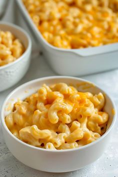 two bowls filled with macaroni and cheese on top of a table