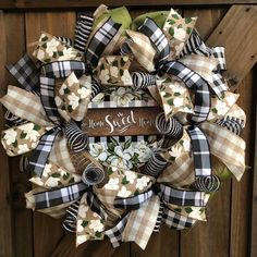 a wreath that has been decorated with flowers and ribbon on the front of a wooden door