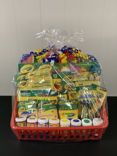 a basket filled with crayons and other items on top of a black table