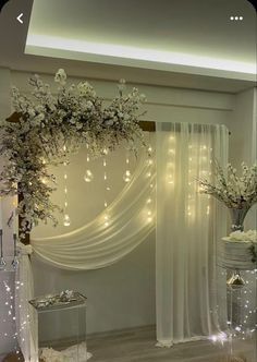 a room decorated with white flowers and lights