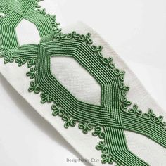 a white and green ribbon with an intricate design on it