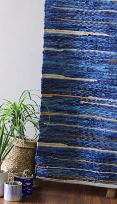 a blue rug sitting on top of a wooden table next to a potted plant