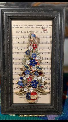 a christmas tree made out of old sheet music is displayed in a shadow box frame