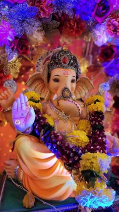 the statue of lord ganesha is surrounded by flowers and garlanded with beads