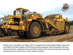 a large yellow truck parked on top of a dirt field